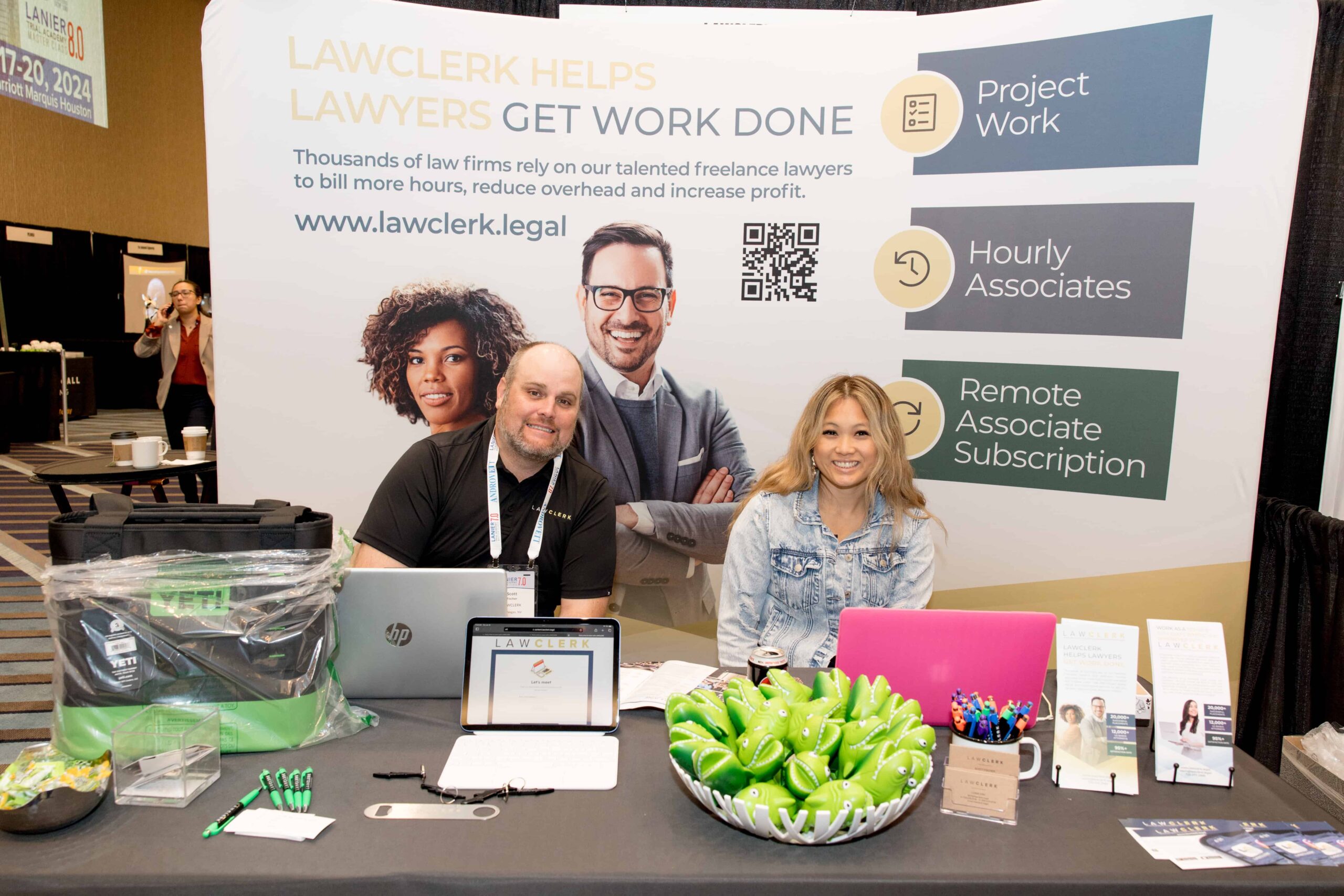 A man and a women sitting at an exhibitor table together