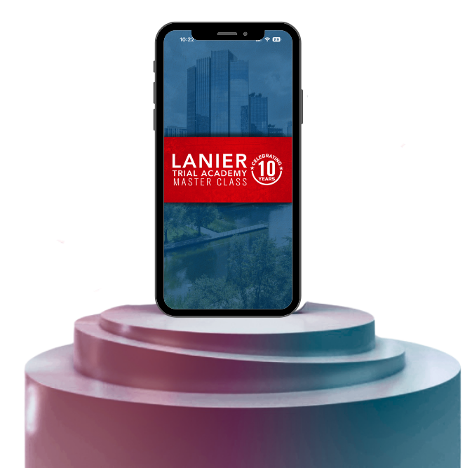 Alt text: A smartphone displayed upright on a tiered pedestal against a dark background, showing a promotional screen that reads “Lanier Trial Academy Master Class” with a red banner and a “10 Years” badge, overlaid on a faint cityscape image.